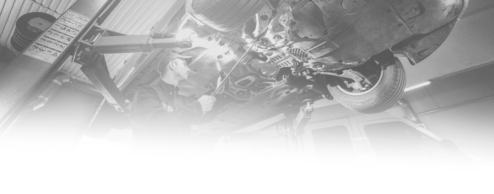 Technician inspecting the underside of a vehicle on a lift at Ben's Automotive